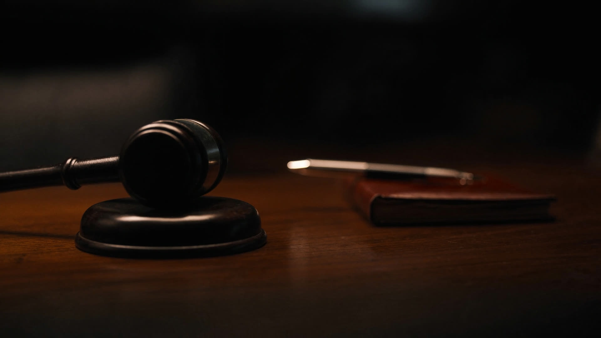 A gavel resting on its sound block on a walnut bench.
